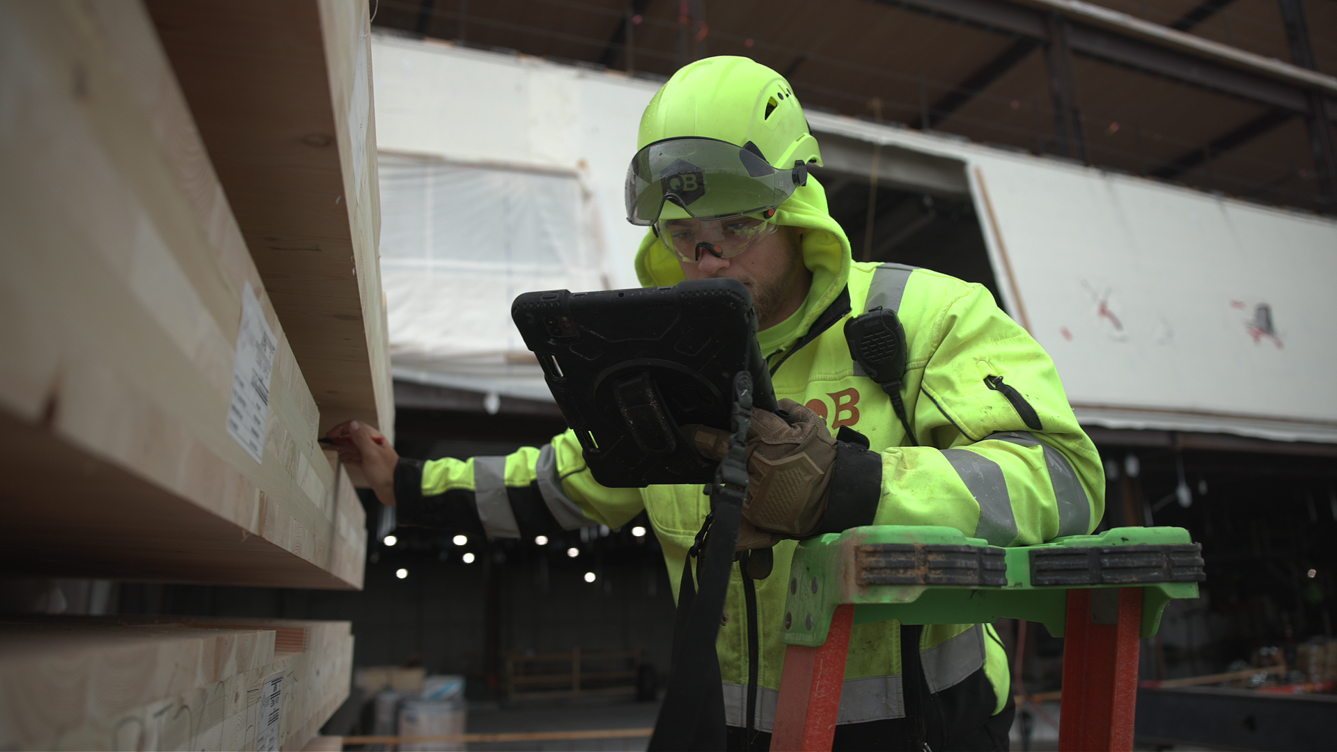 Field coordinator reviewing plans on tablet at mass timber jobsite